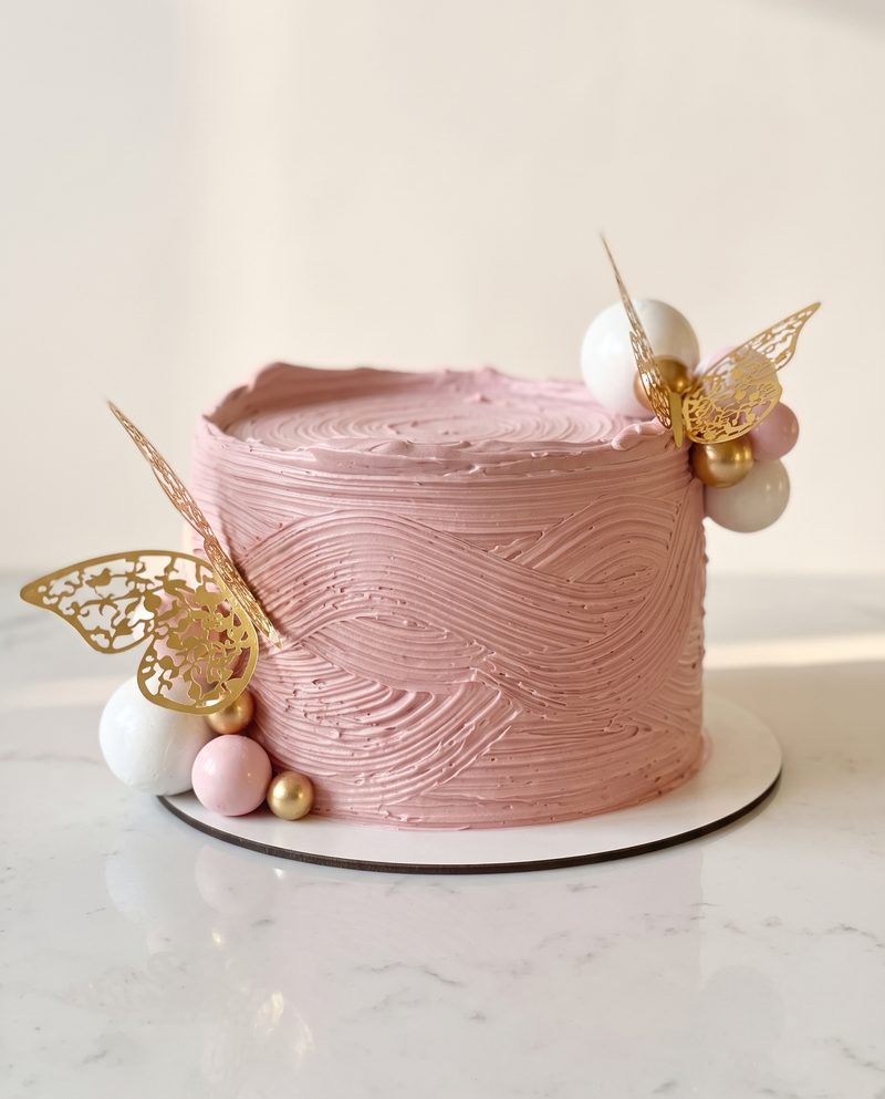 Gâteau rose texturé au papillon doré