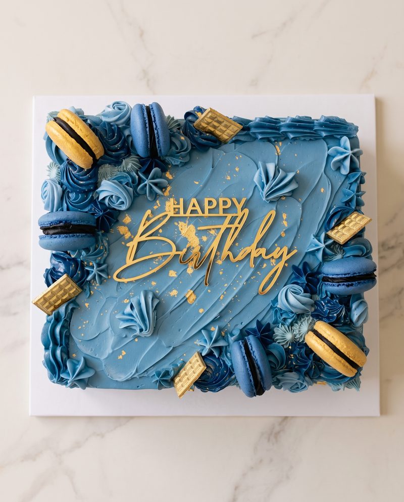 Gâteau d'anniversaire carré bleu, macarons et éclats d'or