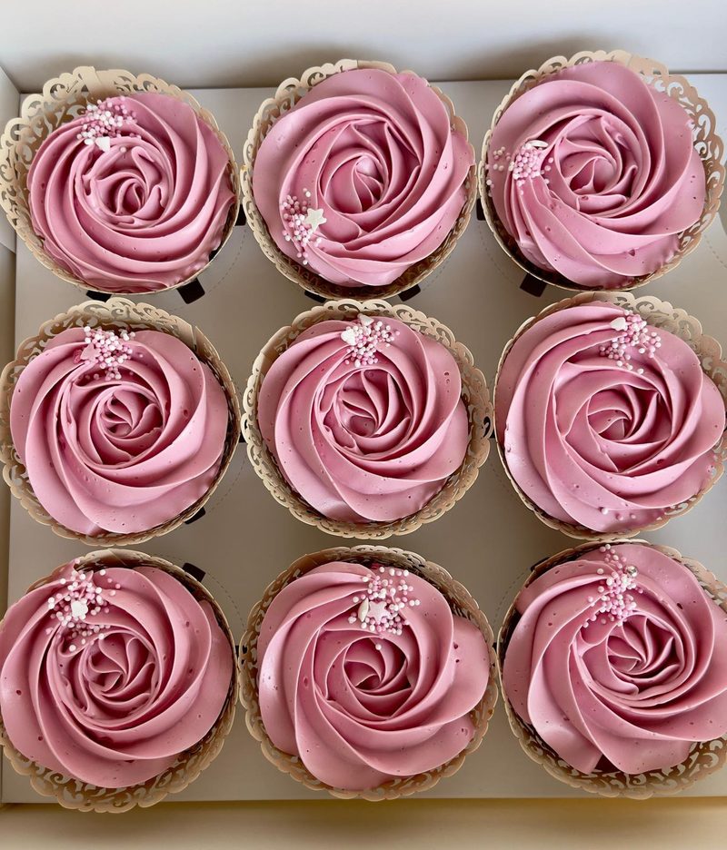 Boîte de neuf cupcakes rose poudré, roses pochées